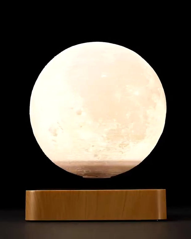 Lunara Levitating Moon Lamp floating above its walnut base, warm white light