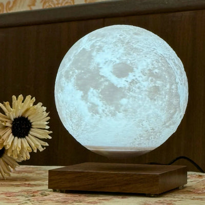 Lunara Levitating Moon Lamp glowing white on wooden base