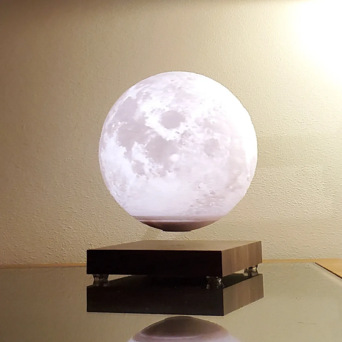 Lunara moon lamp floating above dark wooden base
